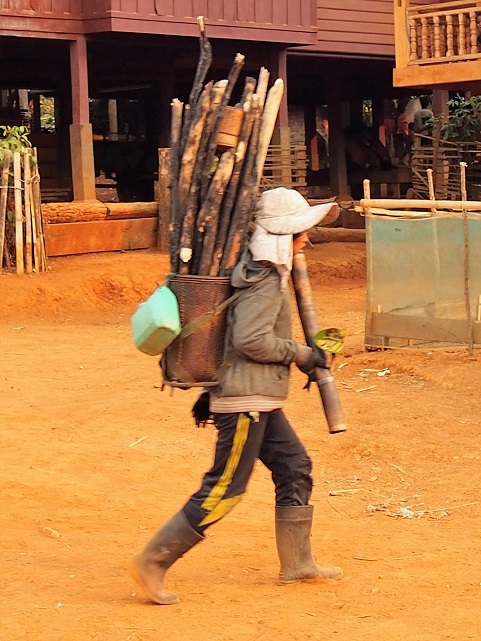 Femme Kétu ramenant du bois en fu,ant 